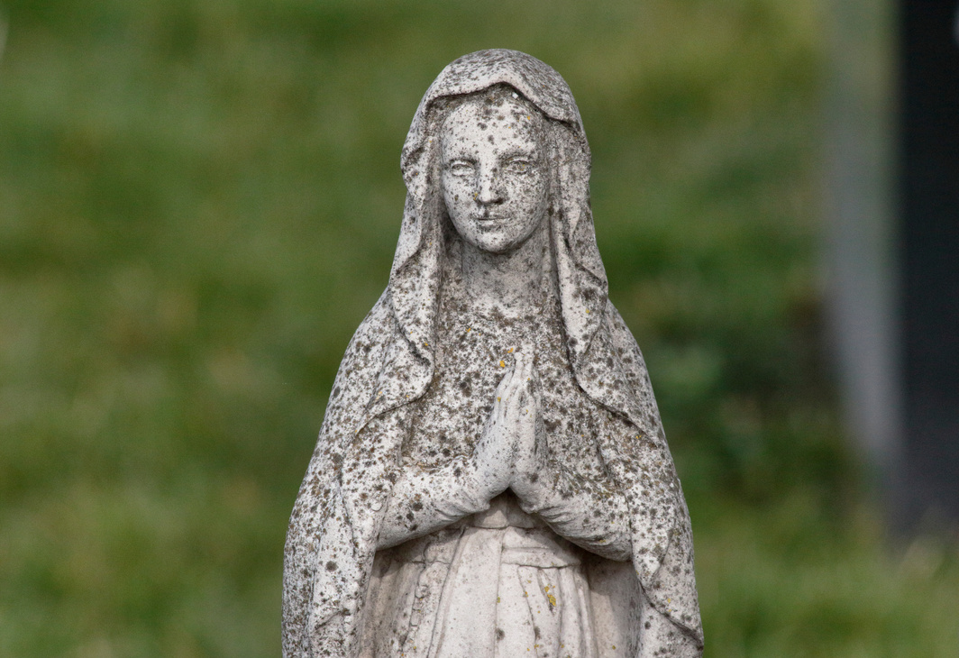 Figure of Mary Magdalene statue in graveyard